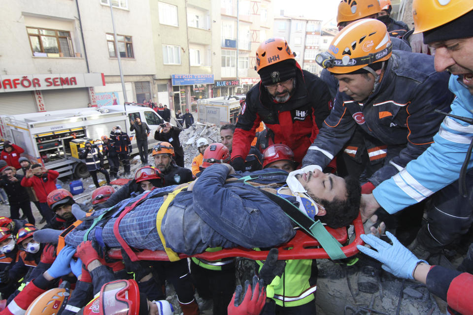 Rescue workers carry a wounded man that was found alive in the rubble of a building destroyed on Friday's earthquake in Elazig, eastern Turkey, Saturday, Jan. 25, 2020. Rescue workers were continuing to search for people buried under the rubble of apartment blocks in Elazig and neighboring Malatya. Mosques, schools, sports halls and student dormitories were opened for hundreds who left their homes after the quake.(Depo Photos via AP)