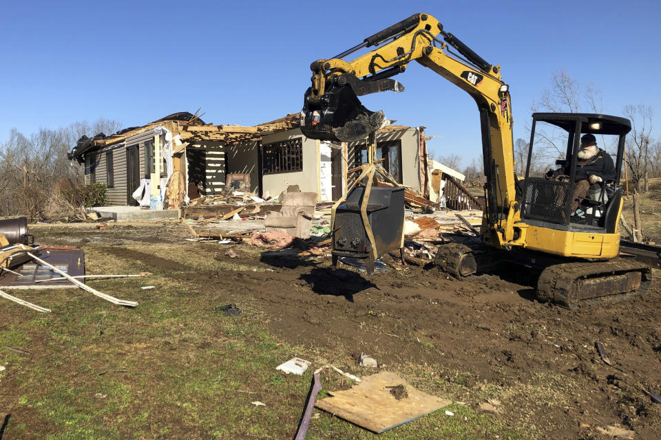 A worker operating heavy equipment removes debris as a home is demolished that was heavily damaged by a tornado on Jan. 11, 2022, in Benton. Ky. The town was one of several struck by a tornado in December. (AP Photo/Adrian Sainz).
