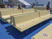 Signs on the seats of the ferry to Giglio island remember travelers to respect social distancing, Tuesday, June 23, 2020. In spite of various people with coronavirus stopped by the island at times, no one of the islanders developed COVID-19 infection. For Paola Muti, a professor of Epidemiology, being trapped by lockdown in her late mother’s house for months on Giglio Island, the situation also made for an opportunity to possibly contribute to scientific understanding of why some people in close contact with people ill with COVID-19 don’t get infected. (AP Photo/Paolo Santalucia)