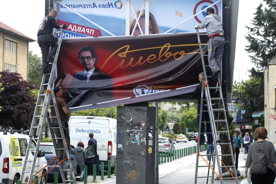 Workers remove an election poster of the incumbent President Stevo Pendarovski from a billboard, a day after the presidential and parliamentary elections, in Skopje, North Macedonia, on Thursday, May 9, 2024. North Macedonia elected its first woman president Wednesday as the governing Social Democrats suffered historic losses in twin presidential and parliamentary elections. (AP Photo/Boris Grdanoski)