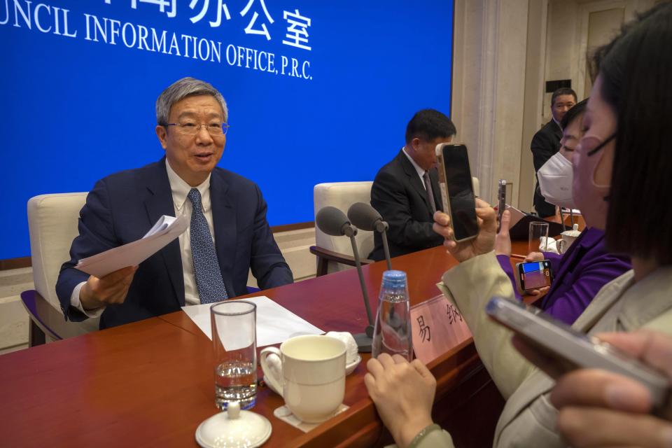 Yi Gang, governor of the People's Bank of China, speaks to journalists after a press conference at the State Council Information Office in Beijing, Friday, March 3, 2023. China's vast real estate industry is recovering from a slump triggered by tighter debt controls, a deputy central bank governor said Friday, after defaults by developers rattled global financial markets. (AP Photo/Mark Schiefelbein)