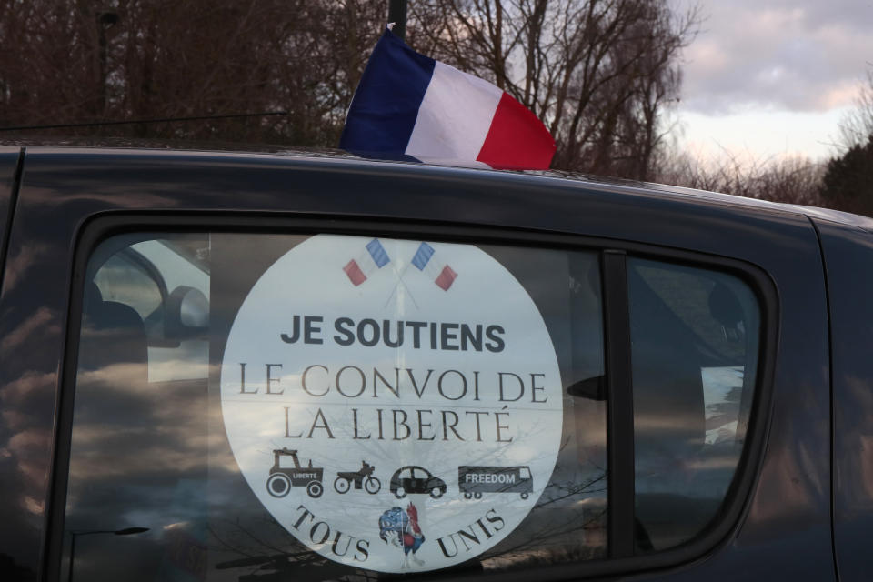 A French flag is fixed on a car part of a "Freedom Convoy" in Lille, northern France, Friday, Feb.11, 2022. Authorities in France and Belgium have banned road blockades threatened by groups organizing online against COVID-19 restrictions. The events are in part inspired by protesters in Canada. Citing "risks of trouble to public order," the Paris police department banned protests aimed at "blocking the capital" from Friday through Monday. Sticker reads: I support the Freedom Convoy. (AP Photo/Michel Spingler)