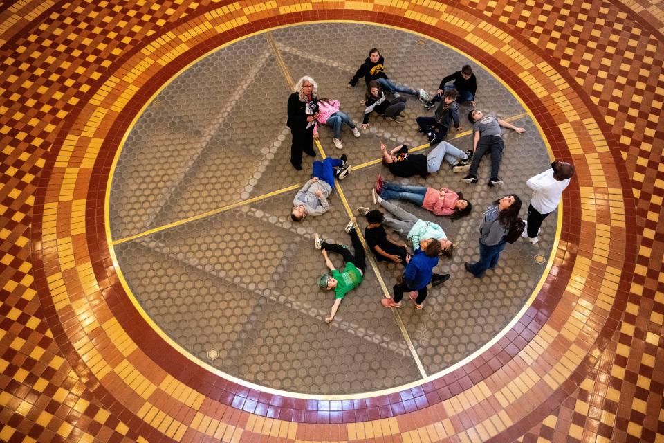 Students from Bondurant-Farrar Community School District look up from the rotunda at the art in the dome ceiling at the Iowa State Capitol on Friday, April 19, 2024, in Des Moines.