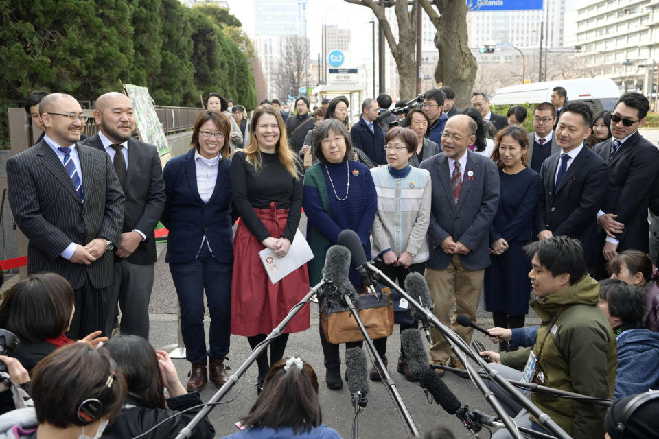 Plaintiffs speak to journalists before they file lawsuits challenging the constitutionality of the country's rejection of same-sex marriage, near Tokyo District Court in Tokyo Thursday, Feb. 14, 2019. The Valentine Day lawsuits argue the law violates same-sex couples' constitutional rights to equality. (Chika Ohshima/Kyodo News via AP)