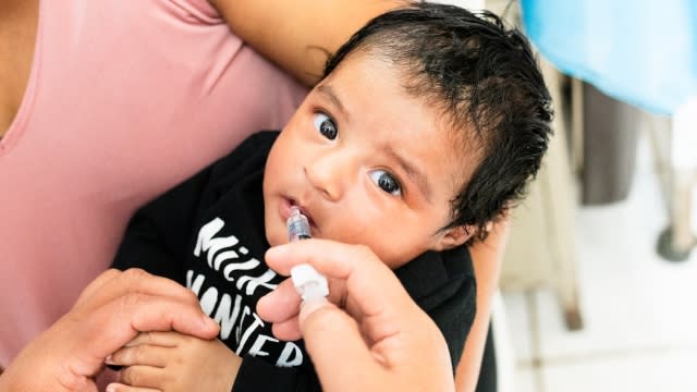 A baby receives an oral vaccination in Latin America.