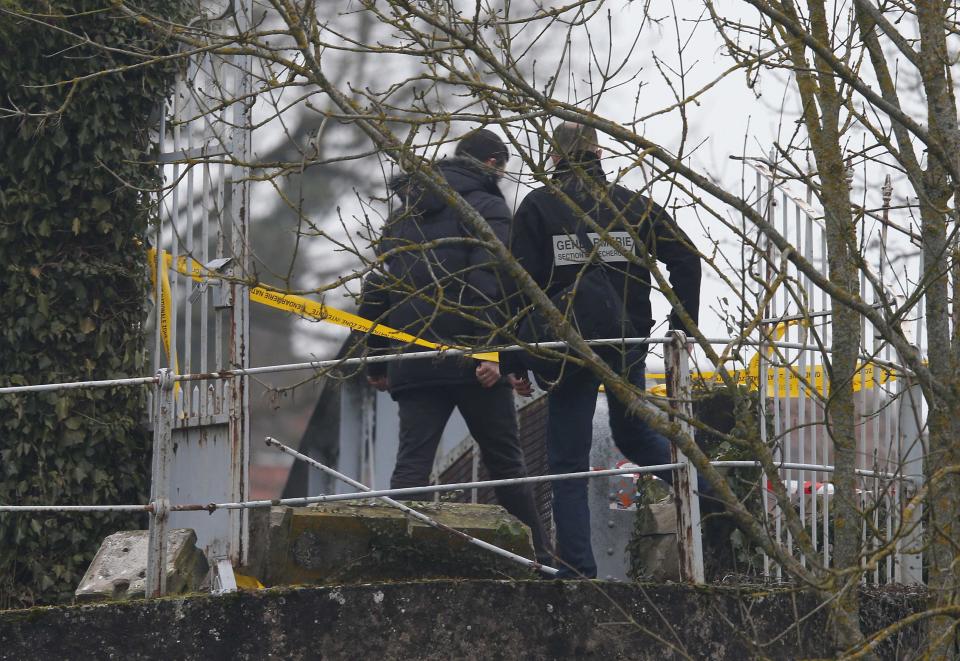 French investigators are seen at the damaged entrance of the Sarre-Union Jewish cemetery, eastern France