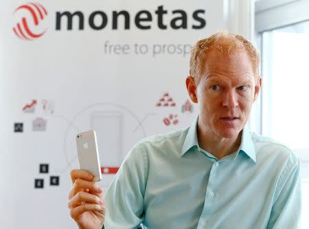 Johann Gevers, founder and CEO of Monetas, holds a mobile phone during an interview with Reuters in Zug, Switzerland, August 30, 2016. REUTERS/Arnd Wiegmann