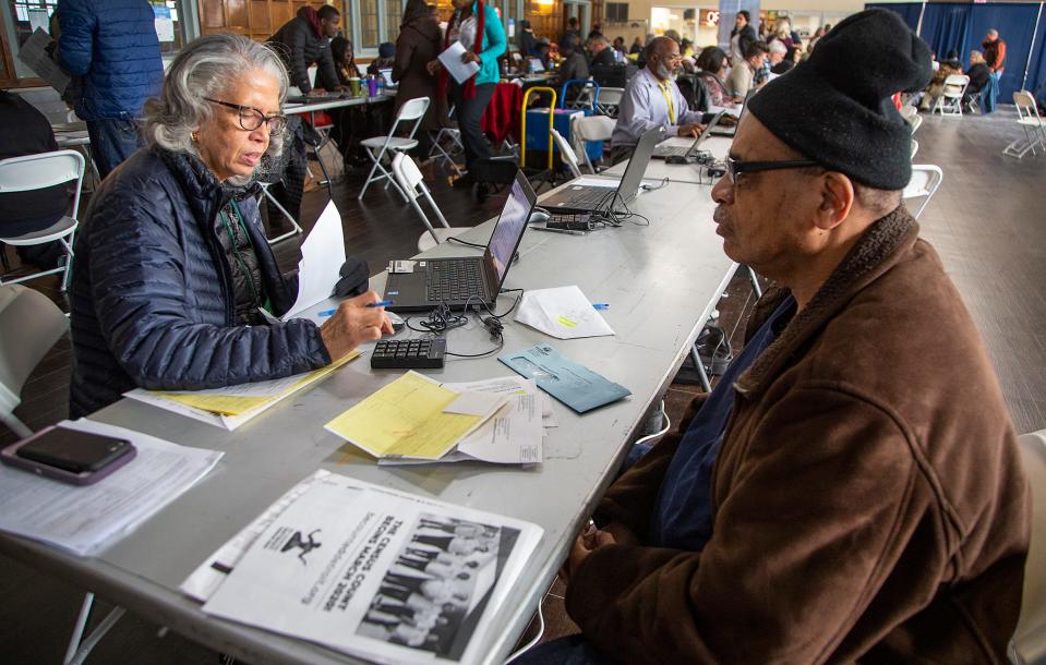 Catherine Campbell, an engineer at Ford Motor, left, volunteers to help tax filers claim the federal Earned Income Tax Credit and state tax credits. Frederick Matthews brought his state tax documents to her at the Durfee Innovation Society in Detroit on Jan. 31, 2020.