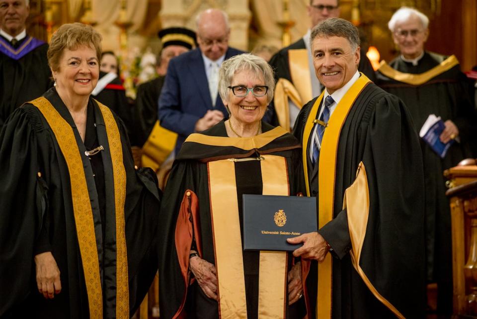 Sally Ross, centre, receives an honorary doctorate in history in 2019 from Université Sainte-Anne. She is a writer and translator who specializes in Acadian history.