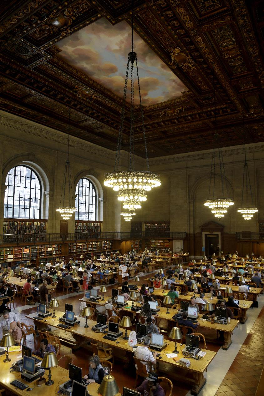 In this Monday, July 22, 2013 photo, patrons use the Rose Reading Room at the main branch of the New York Public Library in New York. Plans for a major change within the New York Public Library’s landmark main building have kindled an intellectual culture clash over its direction and the future of libraries themselves. (AP Photo/Seth Wenig)