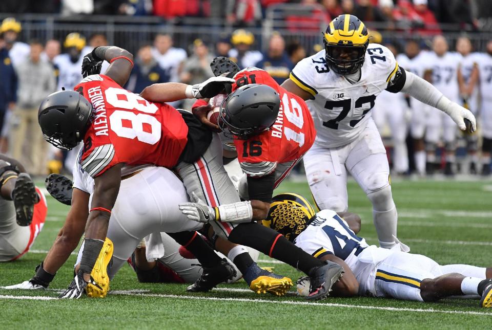 COLUMBUS, OH – NOVEMBER 26: J.T. Barrett #16 of the Ohio State Buckeyes rushes for a first down during overtime of the game against the Michigan Wolverines at Ohio Stadium on November 26, 2016 in Columbus, Ohio. (Photo by Jamie Sabau/Getty Images)