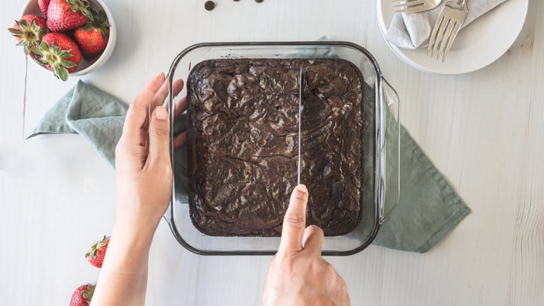 Hands cutting chocolate brownies