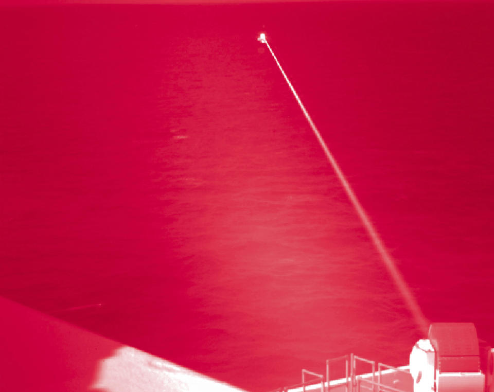 In this handout infrared photo from the U.S. Navy, the USS Portland fires a laser weapon system at a target floating in the Gulf of Aden on Tuesday, Dec. 14, 2021. The U.S. Navy announced Wednesday it tested a laser weapon and destroyed a floating target in the Mideast, a system that could be used to counter bomb-laden drone boats deployed by Yemen's Houthi rebels in the Red Sea. (Mass Communication Specialist 2nd Class Devin Kates/U.S. Marine Corps via AP)