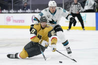 Vegas Golden Knights defenseman Shea Theodore (27) vies for the puck with San Jose Sharks right wing Timo Meier (28) during the third period of an NHL hockey game Wednesday, April 21, 2021, in Las Vegas. (AP Photo/John Locher)