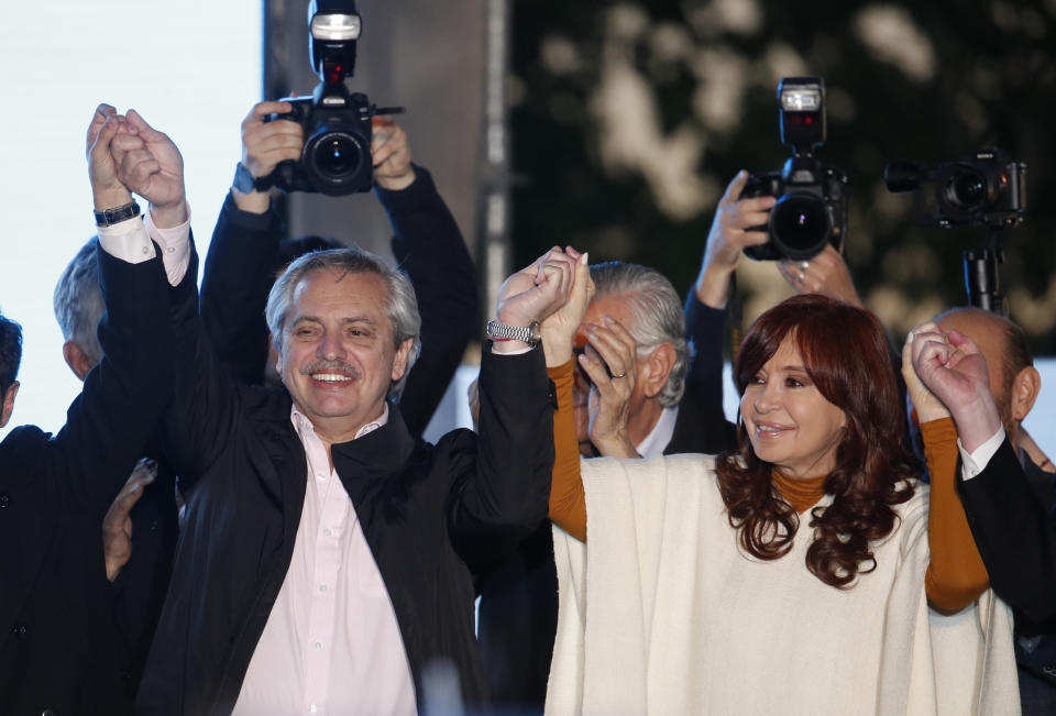 In this Oct. 17, 2019 photo, presidential candidate Alberto Fernandez, left, and running-mate Cristina Fernandez de Kirchner, hold up their hands in unison at a rally in Santa Rosa, Argentina. Supporters chanted “We will return!” as Fernandez de Kirchner, Argentina’s former president, campaigned ahead of national elections on Oct. 27. (AP Photo/Natacha Pisarenko)