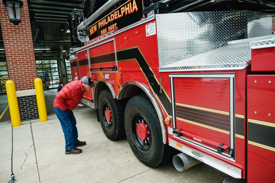 A man inspects the rear-wheel steering system on New Philadelphia's new fire truck, Ladder 2109, during the official push-in ceremony Saturday.