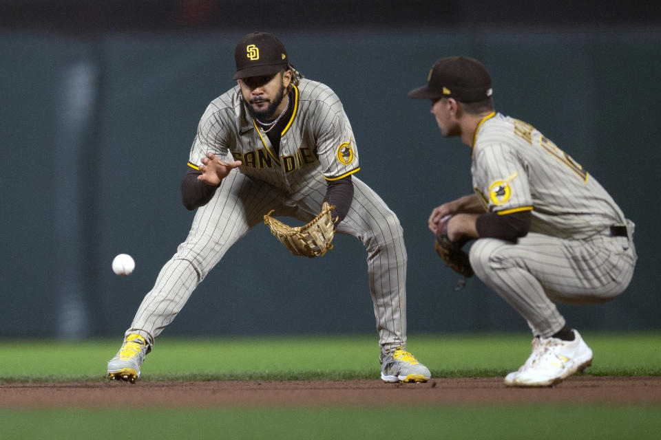 San Diego Padres shortstop Fernando Tatis Jr., left, fields a grounder by San Francisco Giants' Steven Duggar in front of second baseman Adam Frazier during the fourth inning of a baseball game, Tuesday, Sept. 14, 2021, in San Francisco. A runner was forced at second, and Duggar was safe at first. (AP Photo/D. Ross Cameron)