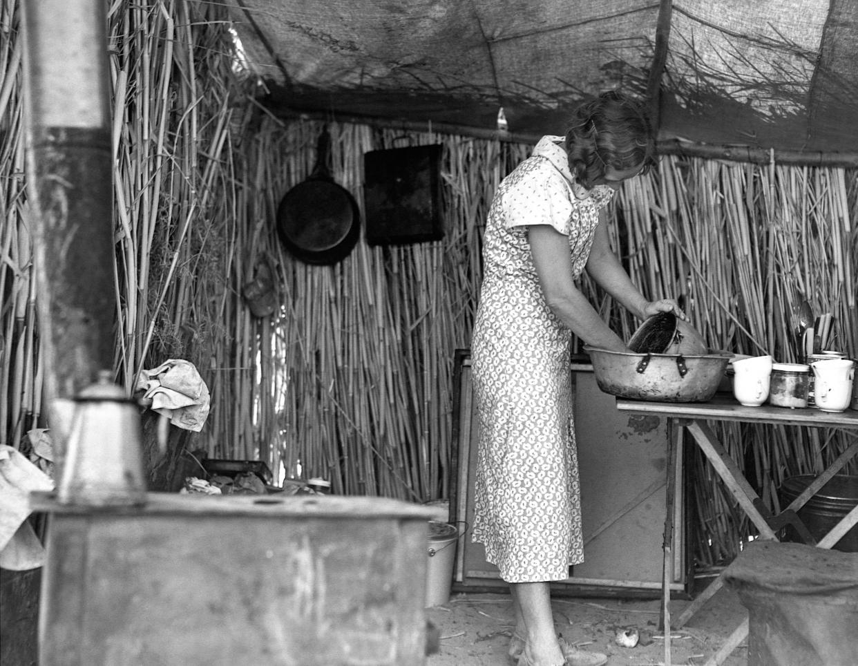 A woman cooking in a camp for migrant agricultrual workers. Imperial Valley, California, ca. February-March 1937.