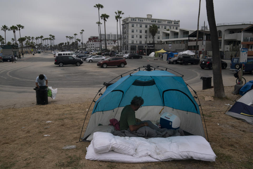 Jose Formoso, who said he moved from Malibu, Calif., after his RV burned down, sits in his tent near the boardwalk in the Venice neighborhood of Los Angeles, Tuesday, June 29, 2021. (AP Photo/Jae C. Hong)