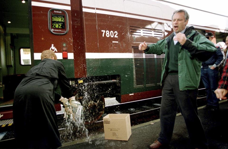 FILE - Rep. Earl Blumenauer, D-Ore., reacts to flying champagne as Oregon Department of Transportation Director Grace Crunican christens Amtrak's newest, sleekest train, at Union Station in Portland, Ore., Monday, Nov. 30, 1998. Blumenauer, a quirky but deeply respected figure in Oregon politics for decades, has decided not to seek reelection after 27 years in Congress, citing turmoil on Capitol Hill and a desire to be more involved in addressing the challenges facing his hometown of Portland. (AP Photo/Don Ryan, File)