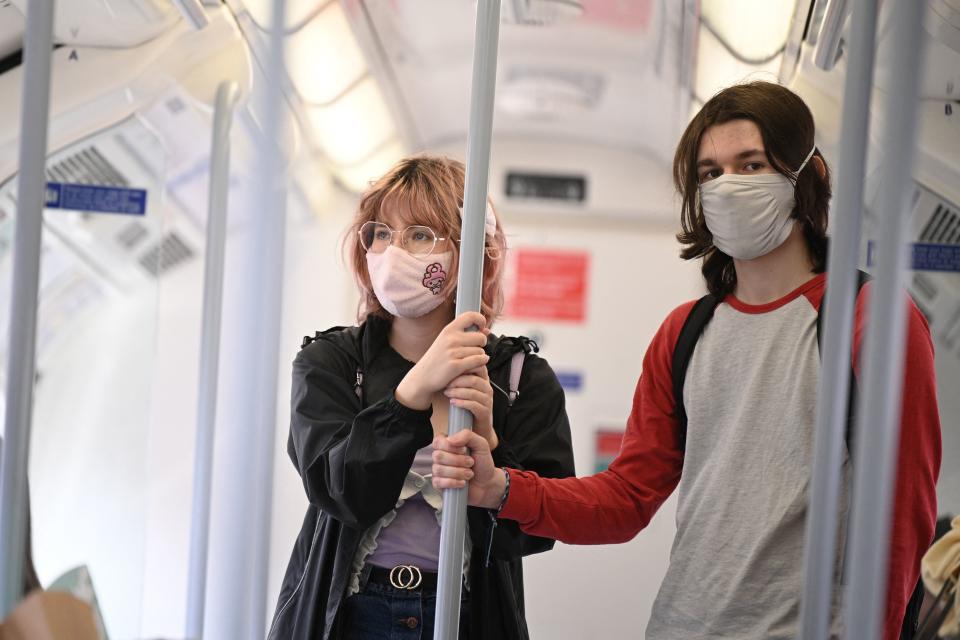 Commuters wearing protective face coverings to combat the spread of the coronavirus, travel on a Transport for London (TFL) Underground train in central London on July 5, 2021. - British Prime Minister Boris Johnson on Monday unveils plans to lift most of the latest health restrictions from 19 July, including the mandatory wearing of face coverings on some forms of public transport. (Photo by DANIEL LEAL-OLIVAS / AFP) (Photo by DANIEL LEAL-OLIVAS/AFP via Getty Images)