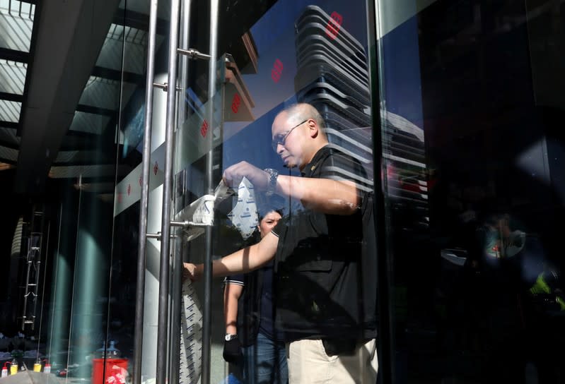 Police close the door to media as members of a safety team established by police and local authorities inspect inside the Hong Kong Polytechnic University (PolyU) in Hong Kong