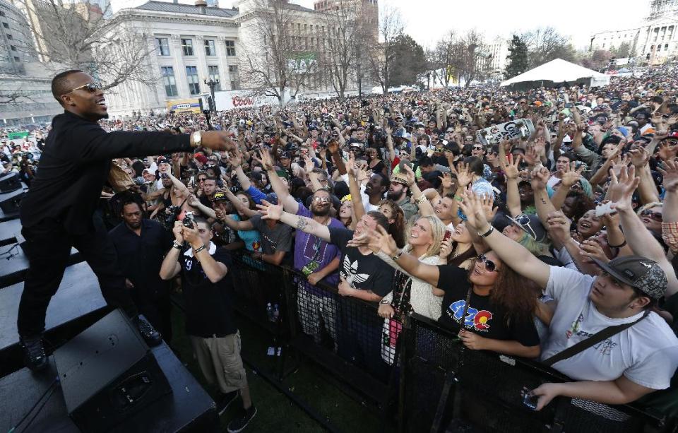 El rapero B.o.B. lanza cigarrillos de marihuana a la muchedumbre en el segundo de dos días del festival anual demarihuana 4/20 en Denver, Colorado, el domingo, 20 de abril del 2014. (Foto AP/Brennan Linsley)