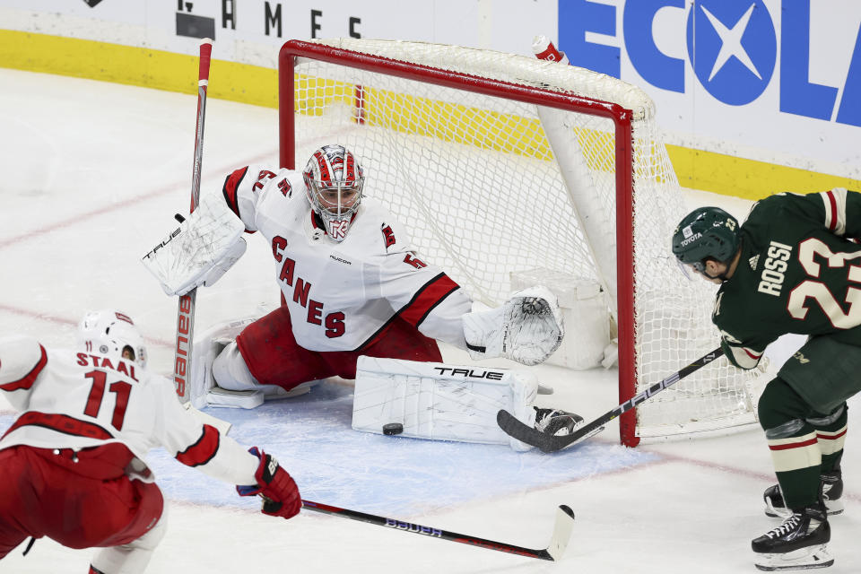 Carolina Hurricanes goaltender Pyotr Kochetkov (52) defends the net against the Minnesota Wild center Marco Rossi (23) during the third period of an NHL hockey game Tuesday, Feb. 27, 2024, in St. Paul, Minn. (AP Photo/Stacy Bengs)