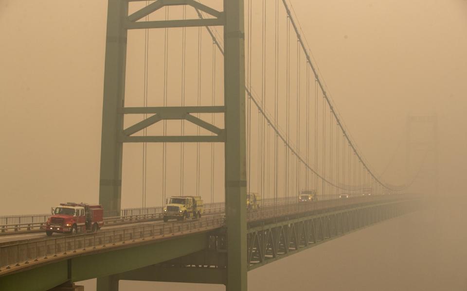 Fire trucks drive over Oroville's Bidwell Bar Bridge in thick smoke.