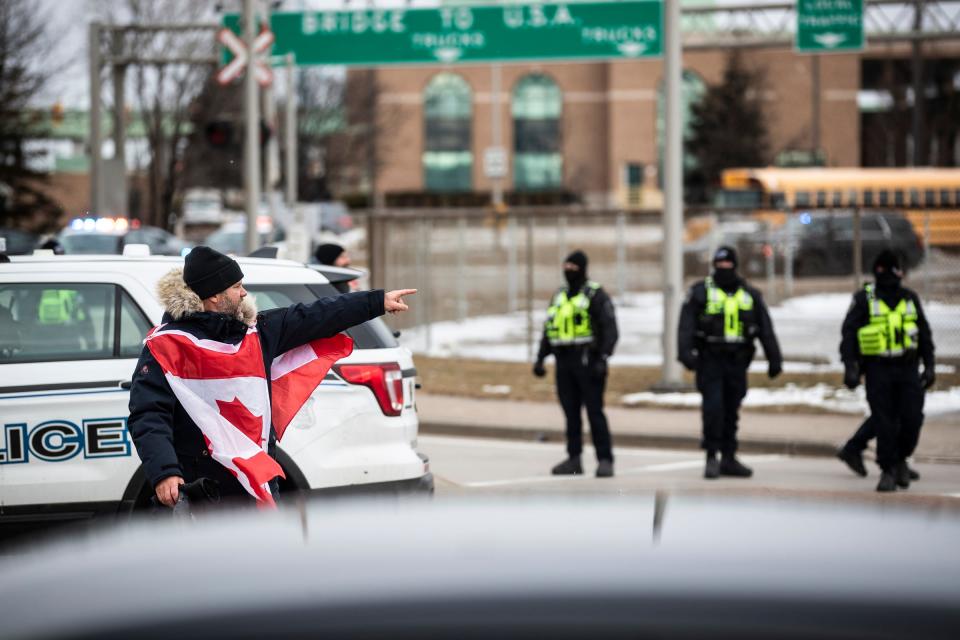 A protester talks to police during an anti-mandate protest on Huron Church Road in Windsor, ON., on Feb. 12, 2022.
