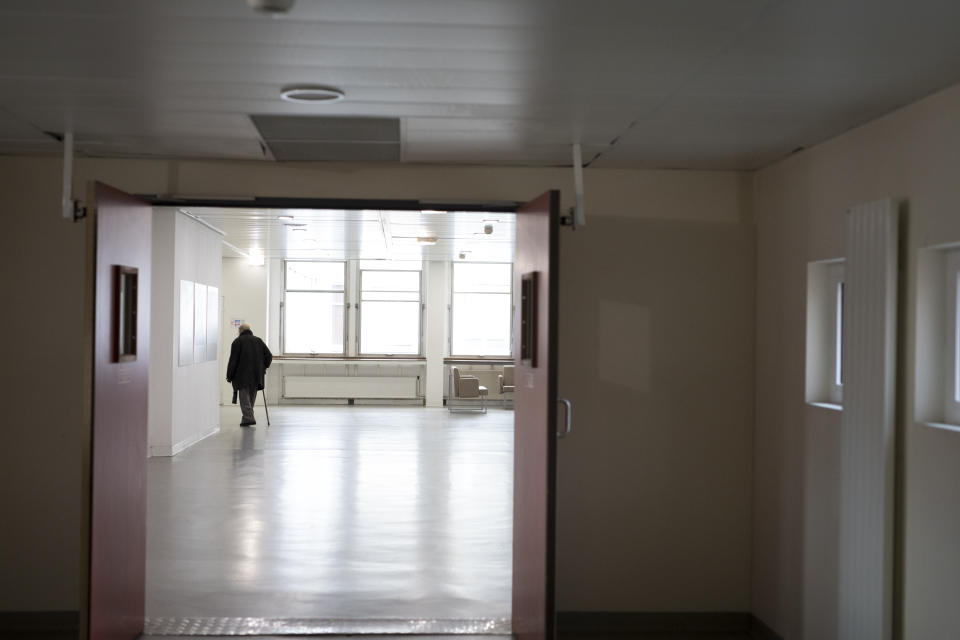 In this photo taken on Dec. 16, 2019 a man with a walking stick walks through the lobby of Marseille's La Timone hospital, southern France. In a hospital in Marseille, student doctors are holding an exceptional, open-ended strike to demand a better future. France’s vaunted public hospital system is increasingly stretched to its limits after years of cost cuts, and the interns at La Timone - one of the country’s biggest hospitals - say their internships are failing to prepare them as medical professionals. Instead, the doctors-in-training are being used to fill the gaps. (AP Photo/Daniel Cole)