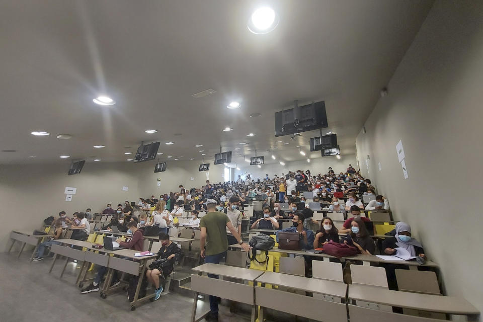 In this photo provided by Sarah Amaziane, students attend a class at La Sorbonne university in Paris, Thursday, Sept.17, 2020. In the century-old lecture theaters of La Sorbonne university in Paris, students are so numerous that some need to sit on the stairs, all wearing a mask but worried about not respecting physical distance that is normally required amid the virus crisis. (Sarah Amaziane via AP)