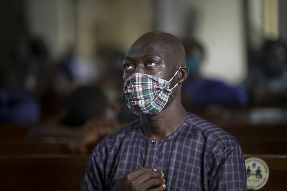 A churchgoer wears a face mask to curb the spread of the coronavirus during a Sunday mass at the Holy Cross Cathedral in Lagos, Nigeria Sunday, Aug. 30, 2020. The COVID-19 pandemic is testing the patience of some religious leaders across Africa who worry they will lose followers, and funding, as restrictions on gatherings continue. (AP Photo/Sunday Alamba)