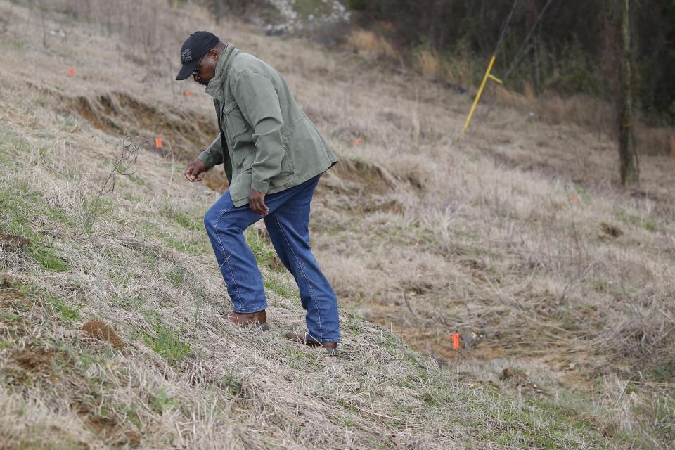 Supervisor Marvell Howard inspects the slope failure as he climbs up the side of the Oktibbeha County Lake dam west of Starkville, Miss., Wednesday, Jan. 15, 2020. Officials said a breach would affect an estimated 130 properties and nine highways. (AP Photo/Rogelio V. Solis)