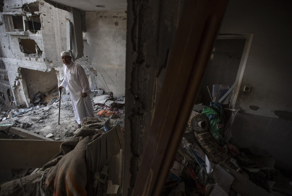 FILE - Palestinians search through the rubble of a building in which Khaled Mansour, a top Islamic Jihad militant was killed following an Israeli airstrike in Rafah, southern Gaza strip, Sunday, Aug. 7, 2022. (AP Photo/Yousef Masoud, File)