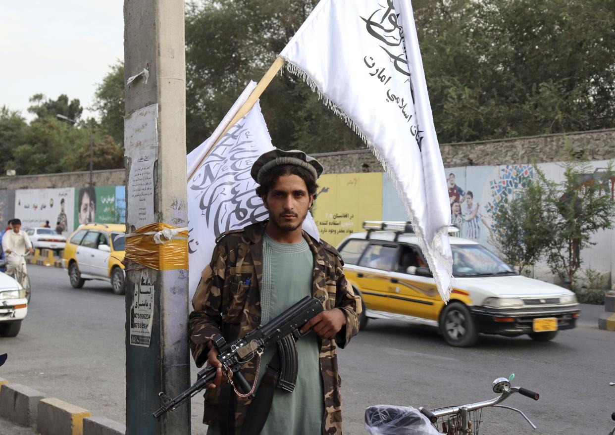 A Taliban fighter holds his weapon under Taliban flags hanging on a street in Kabul, Afghanistan on Aug. 30, 2021.
