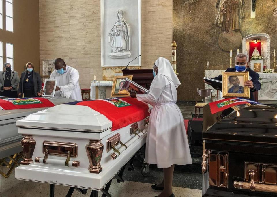 Funcionarios de la iglesia colocan fotos de las 11 mujeres haitianas que murieron el mes pasado cuando el barco sobrecargado en el que viajaban volcó, en una iglesia en San Juan, Puerto Rico, el miércoles 15 de junio de 2022.