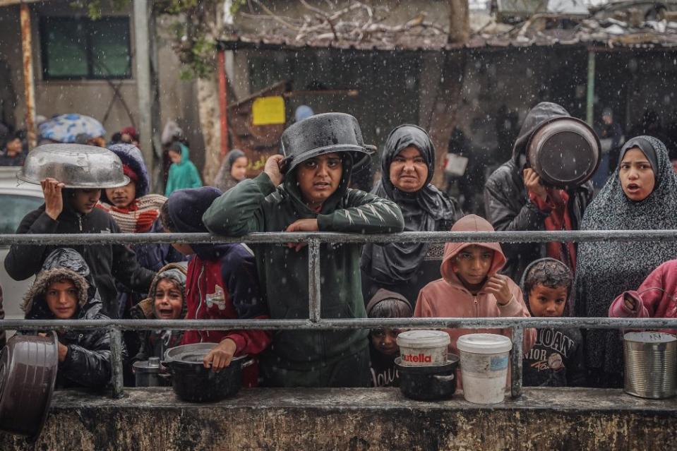 Palestinians wait for food at a donation center in a refugee camp in Rafah on January 27, 2024.