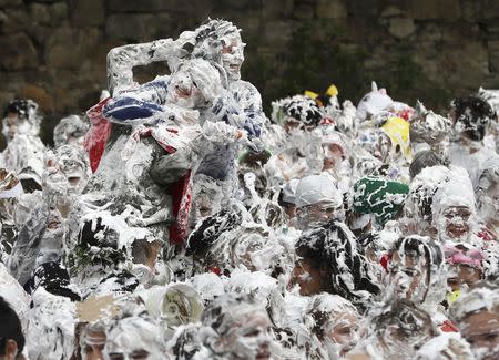 Students from St Andrews University are covered in foam as they take part in the traditional 'Raisin Weekend' in the Lower College Lawn, at St Andrews in Scotland, Britain October 17, 2016. REUTERS/Russell Cheyne