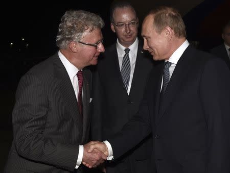 Russia's President Vladimir Putin (R) shakes hands with Governor of Queensland Paul de Jersey (L) as Official Secretary to Australia’s Governor-General Mark Fraser looks on, after arriving at the G20 Terminal in Brisbane in this November 14, 2014 picture provided by G20 Australia. REUTERS/G20 Australia/Handout via Reuters