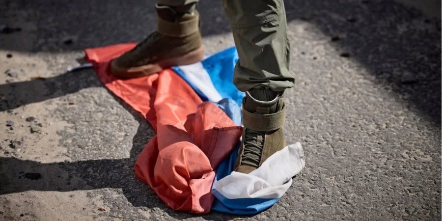 A man tramples the flag of the Russian Federation in Kupyansk, Kharkiv Oblast