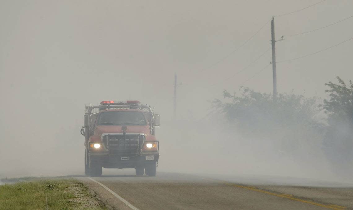 A fire truck passes a spot on 1287 where flames flared up unchecked south of Graham on April 15, 2011.