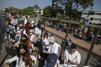 Wearing masks to curb the spread of the new coronavirus, musicians join pianist, composer and conductor Jose Agustin Sanchez on the bed of an eighteen-wheeler truck for a musical tour called "Musical Disinfection," in Barquisimeto, Venezuela, Thursday, March 4, 2021. Sanchez, who last year started playing what he calls his "Musical Vaccine" for COVID patients, is now joined by other musicians as they ride through the city playing his original compositions for anybody that wants to listen. (AP Photo/Ariana Cubillos)