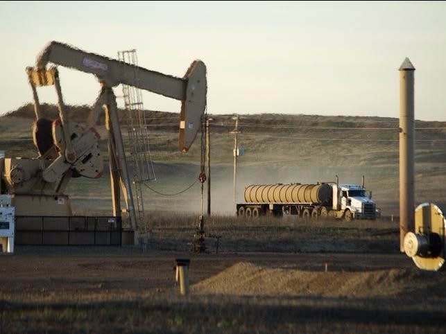 A service truck drives past an oil well on the Fort Berthold Indian Reservation in North Dakota, November 1, 2014.   REUTERS/Andrew Cullen  