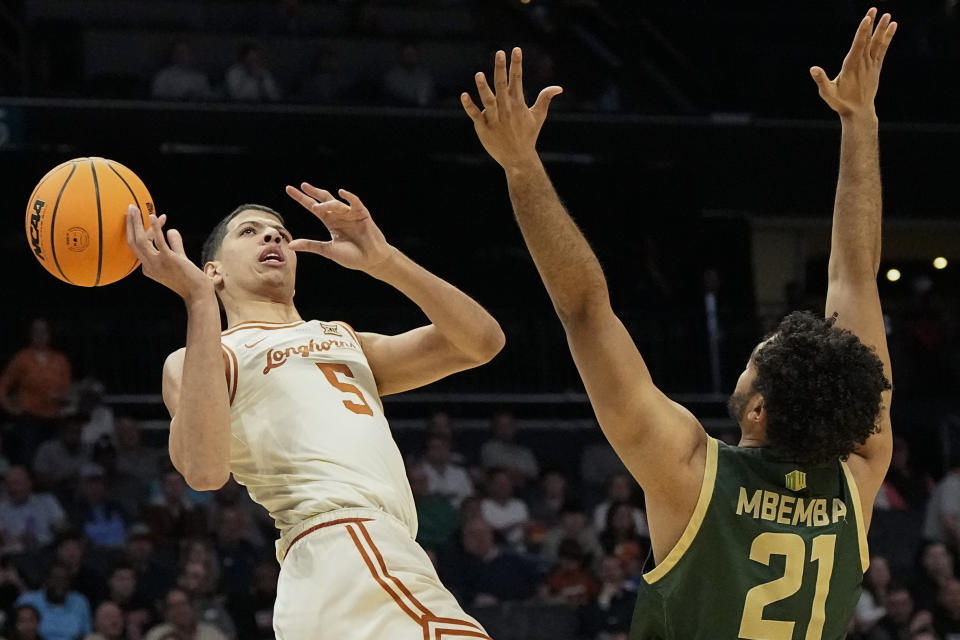 Texas forward Kadin Shedrick (5) loses the ball against Colorado State guard Rashaan Mbemba (21) during the first half of a first-round college basketball game in that NCAA Tournament, Thursday, March 21, 2024, in Charlotte, N.C. (AP Photo/Mike Stewart)