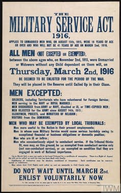 Historical military service act proclamation, white background with blue text reading THE MILITARY SERVICE ACT, 1916, APPLIES TO UNMARRIED MEN WHO, ON AUGUST 15th, 1915, WERE 18 YEARS OF AGE OR OVER AND WHO WILL NOT BE 41 YEARS OF AGE ON MARCH 2nd, 1916.