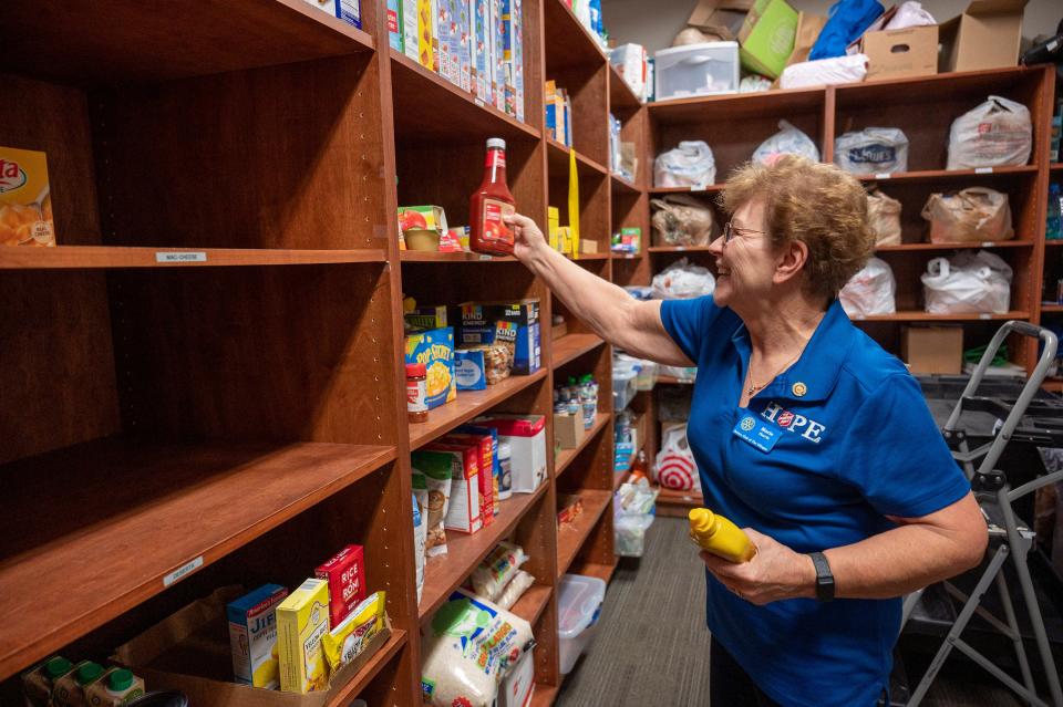 Volunteer Marie Harris stocks the shelves with food donations at the Salvation Army food pantry in Leesburg. [Cindy Peterson/Correspondent]