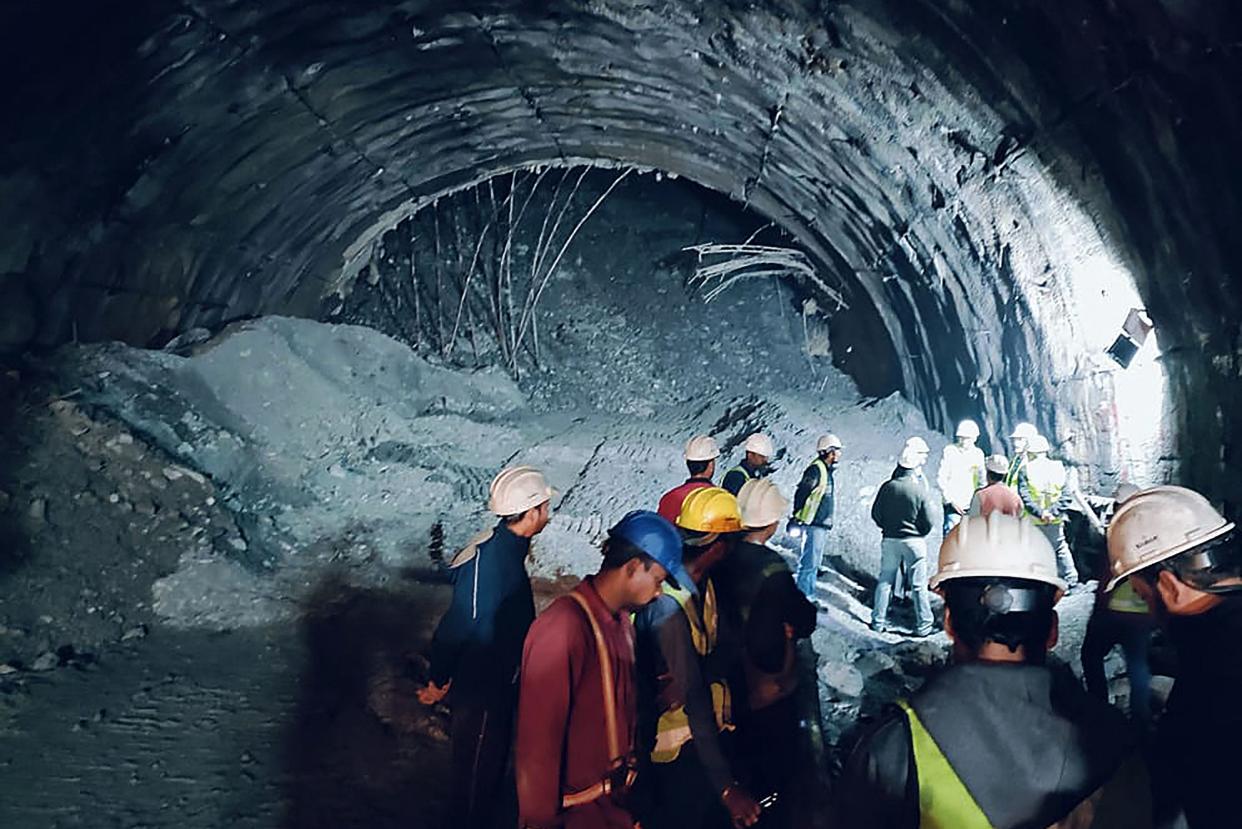 In this photograph taken on November 12, 2023, rescue workers gather at the site after a tunnel collapsed in the Uttarkashi district of India's Uttarakhand state. Rescue workers in northern India said on November 13 they had made contact with 40 workers trapped for over 24 hours after the road tunnel they were building collapsed.