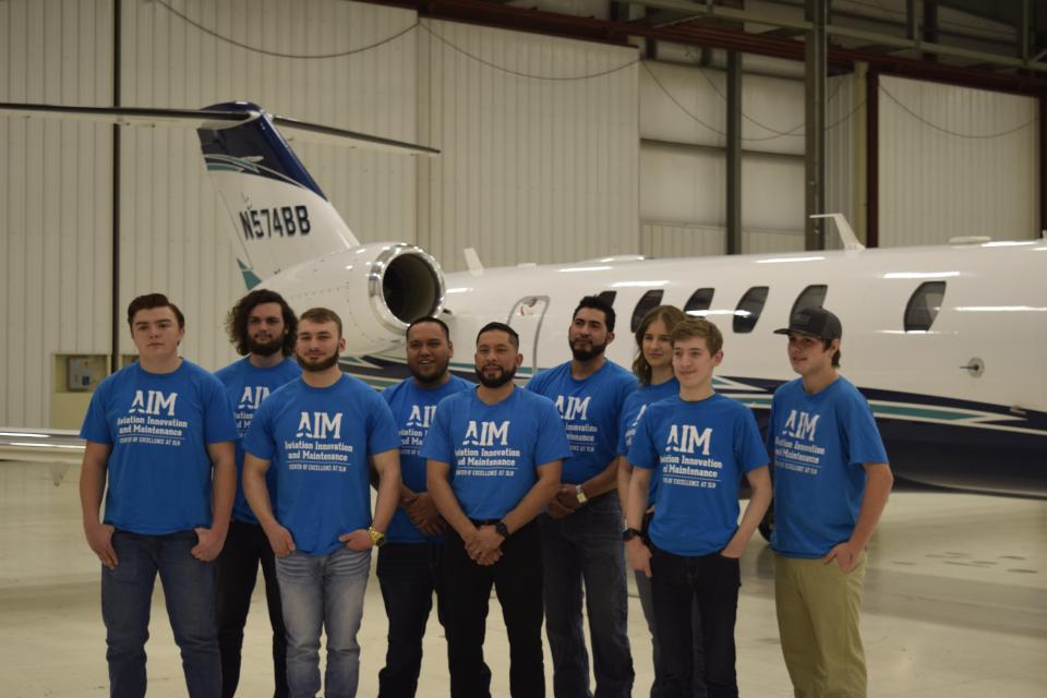 The first cohort of students for the Aviation Innovation and Maintenance (A.I.M.) Center of Excellence at Salina Regional Airport stand in front of a Cessna Citation jet. The airport hosted the first graduation of the A.I.M. program Thursday.