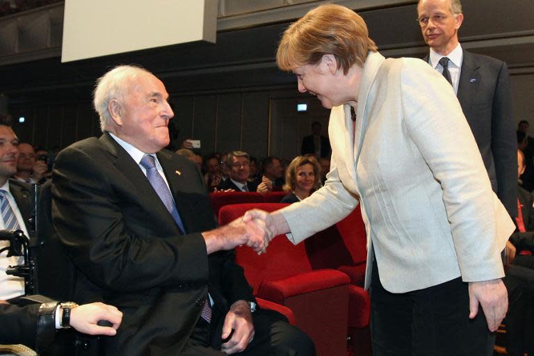 German chancellor Angela Merkel (R) shakes hands with former chancellor Helmut Kohl (L) on April 23, 2015